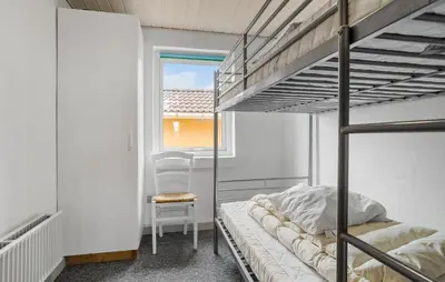a bedroom with two bunk beds and a chair at Pet Friendly Home In Thisted With Sauna in Thisted