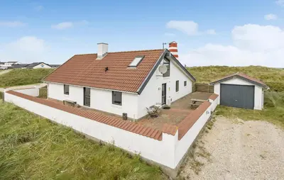 a white house with a red roof on the beach at Awesome Home In Thisted With Sauna in Thisted