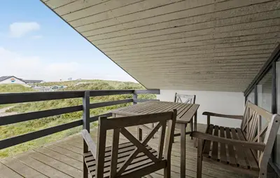 a wooden deck with two chairs and a wooden table at Awesome Home In Thisted With Sauna in Thisted