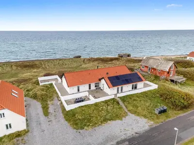 an aerial view of a house with the ocean behind it at Pool And Activity House With A 180-Degree View Of The North Sea, Located At Lild Strand in Frøstrup