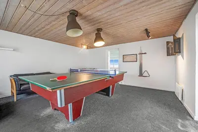 a ping pong table in a room with a ceiling at Pool And Activity House With A 180-Degree View Of The North Sea, Located At Lild Strand in Frøstrup