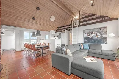 a living room with a couch and a table at Pool And Activity House With A 180-Degree View Of The North Sea, Located At Lild Strand in Frøstrup
