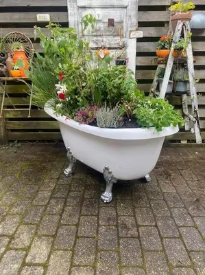 a white bath tub filled with plants and flowers at En SMUK og CHARMERENDE OASE meget tæt på centrum! in Holstebro