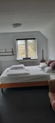 a bedroom with two beds and a window at Dybvad Mølle bed and breakfast in Års