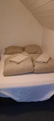 a bed in a room with two pillows on it at Dybvad Mølle bed and breakfast in Års