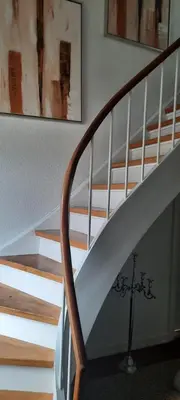 a staircase in a home with a white stair case at Dybvad Mølle bed and breakfast in Års