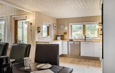 a kitchen with a table and chairs in a room at Gorgeous Home In Blokhus With Sauna in Blokhus