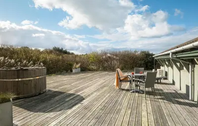 a wooden deck with a table and chairs on it at Pet Friendly Home In Blokhus With Wifi in Blokhus