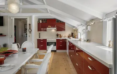 a kitchen with red cabinets and a white counter top at Pet Friendly Home In Blokhus With Wifi in Blokhus