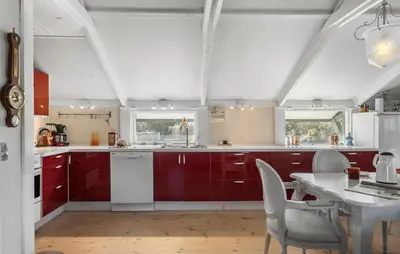 a kitchen with red cabinets and a white table at Pet Friendly Home In Blokhus With Wifi in Blokhus