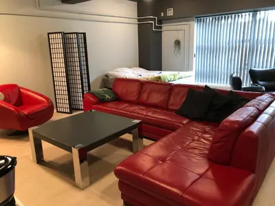 a living room with a red leather couch and a table at Struer Festcenter - Vest Bowl lejlighed 1 Bredgade 62 C in Struer