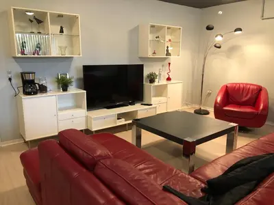 a living room with a couch and a table and a television at Struer Festcenter - Vest Bowl lejlighed 1 Bredgade 62 C in Struer