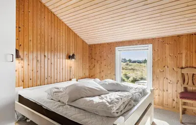 a bedroom with a bed in a wooden wall at Pet Friendly Home In Thisted With Sauna in Thisted