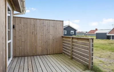 a wooden fence on a deck next to a house at Beautiful Home In Thisted in Thisted