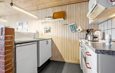 a kitchen with white appliances and wooden walls at Beautiful Home In Thisted in Thisted
