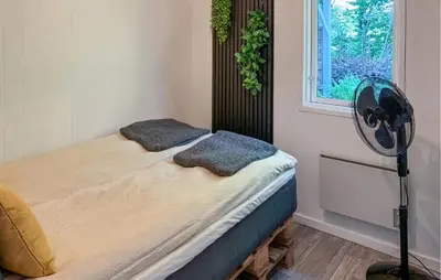 a bedroom with a bed with a fan and a window at Awesome Home In Hjerm With Wifi in Hjerm