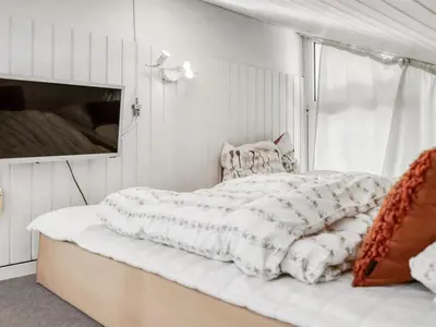 a bed with a white comforter in a bedroom at Holiday Home Arild - 900m from the sea by Interhome in Saltum