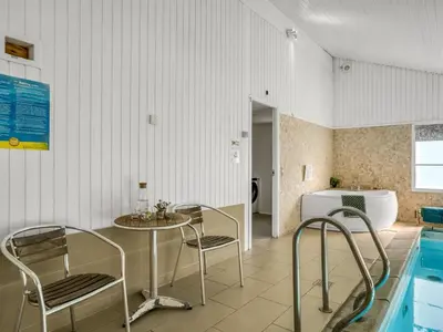 a room with a table and chairs and a swimming pool at Holiday Home Arild - 900m from the sea by Interhome in Saltum
