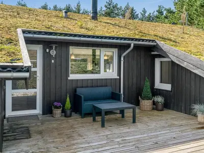 a tiny house with a blue couch on a deck at Holiday Home Arild - 900m from the sea by Interhome in Saltum