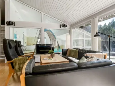 a living room with a black couch and a table at Holiday Home Arild - 900m from the sea by Interhome in Saltum