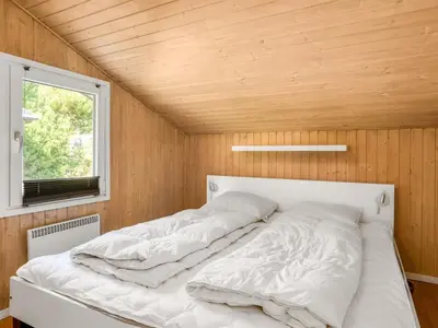 a white bed in a room with a wooden ceiling at Holiday Home Arild - 900m from the sea by Interhome in Saltum