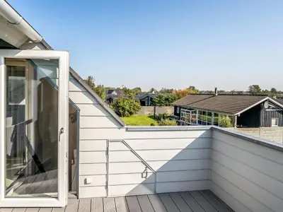 a balcony with a sliding glass door on a house at Holiday Home Isabel - 600m from the sea by Interhome in Blokhus