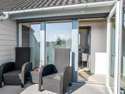 a screened in porch with two chairs and a table at Holiday Home Isabel - 600m from the sea by Interhome in Blokhus