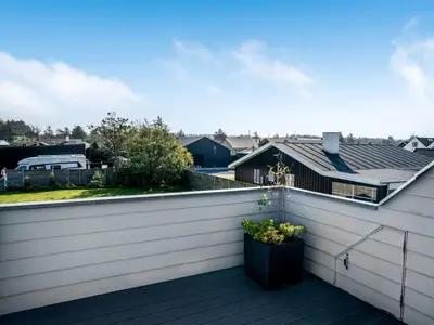 a balcony with a white fence and a plant at Holiday Home Isabel - 600m from the sea by Interhome in Blokhus