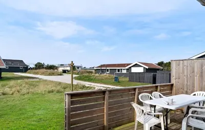 a patio with a table and chairs on a fence at 2 Bedroom Cozy Home In Thisted in Thisted