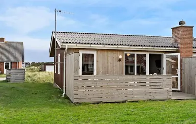 a small house with a wooden fence in a yard at 2 Bedroom Cozy Home In Thisted in Thisted
