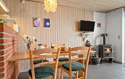 a dining room with a table and chairs and a television at 2 Bedroom Cozy Home In Thisted in Thisted