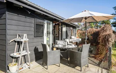 a patio with an umbrella and a table and chairs at 2 Bedroom Nice Home In Løgstør in Løgstør
