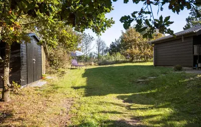 a yard with a building and a bench in the grass at 2 Bedroom Nice Home In Løgstør in Løgstør