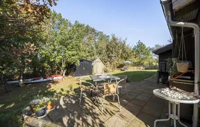 a patio with a table and chairs in a backyard at 2 Bedroom Nice Home In Løgstør in Løgstør