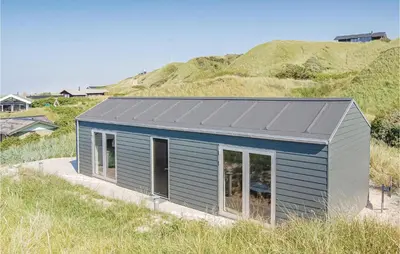 a blue house with a grey roof on a hill at Five-Bedroom Holiday Home Løkken With A Room Hot Tub 04 in Løkken