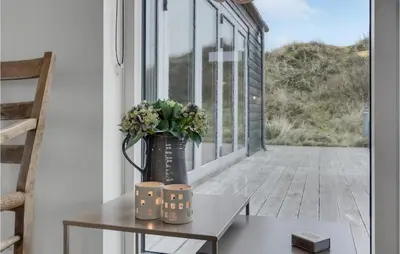 a vase with flowers on a table on a balcony at Five-Bedroom Holiday Home Løkken With A Room Hot Tub 04 in Løkken
