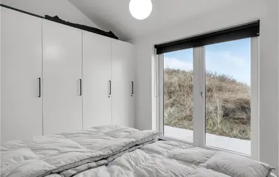 a bedroom with a bed and a large window at Five-Bedroom Holiday Home Løkken With A Room Hot Tub 04 in Løkken