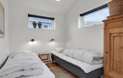 a bedroom with two beds and two windows at Five-Bedroom Holiday Home Løkken With A Room Hot Tub 04 in Løkken