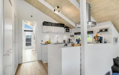 a kitchen with white cabinets and a wooden ceiling at Three-Bedroom Holiday Home Harboøre With A Fireplace 06 in Harboør