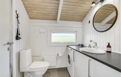 a bathroom with a toilet sink and a mirror at Three-Bedroom Holiday Home Harboøre With A Fireplace 06 in Harboør