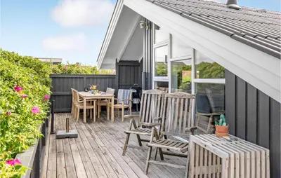 a wooden deck with chairs and a table at Three-Bedroom Holiday Home Harboøre With A Fireplace 06 in Harboør