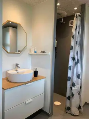 a bathroom with a sink and a shower curtain at Aneks i rolige omgivelser-adgang til pool og sauna in Avlum