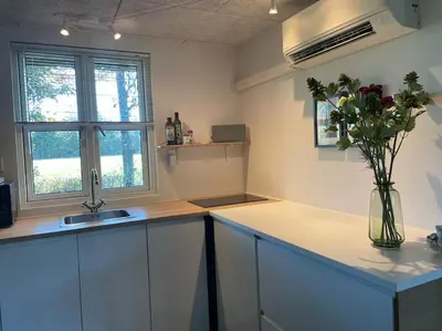 a kitchen with a sink and a vase of flowers at Aneks i rolige omgivelser-adgang til pool og sauna in Avlum