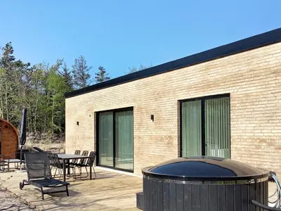 a brick building with a grill and a table and chairs at 5 star holiday home in Vestervig-By Traum in Vestervig