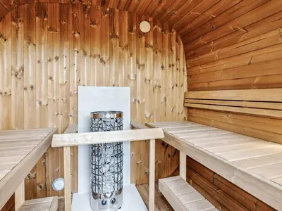 a wooden sauna with two benches and a trash can at 5 star holiday home in Skals in Skals
