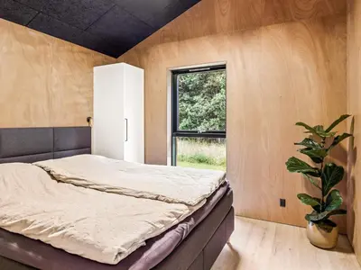 a bedroom with a bed and a potted plant at 5 star holiday home in Skals in Skals