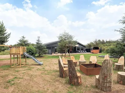 a playground with wooden logs and a slide at 5 star holiday home in Højslev in Højslev