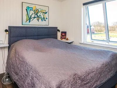 a bedroom with a large bed and a window at 4 person holiday home in Lemvig in Lemvig