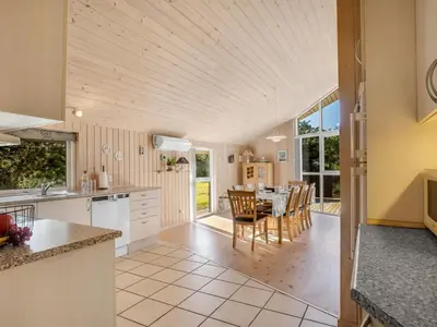 a kitchen and dining room with a table and chairs at Holiday Home Skrollan - 200m to the fjord by Interhome in Sindrup