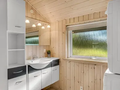 a bathroom with a sink and a window at Holiday Home Skrollan - 200m to the fjord by Interhome in Sindrup